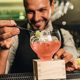 A man is sitting at the bar with a drink.