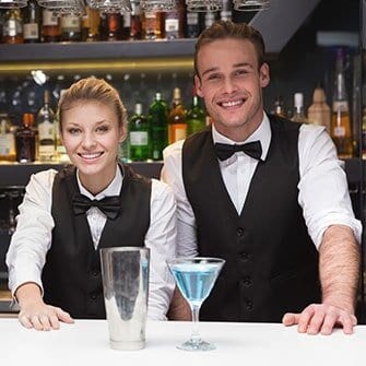 Two people in a bar with drinks on the table